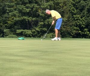 Golfer putting on a green golf course.